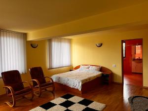 a bedroom with a bed and two chairs at Vila Ovi Salin in Turda +229 photos