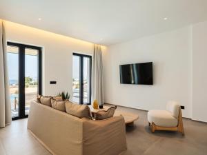 a living room with a couch and a tv at Villa Sabbia in Mesochórion