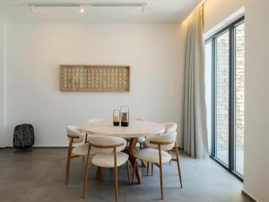 a white dining room with a table and chairs at Villa Sabbia in Mesochórion