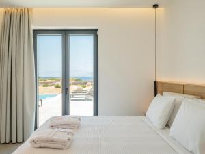 a bedroom with a bed with a view of the ocean at Villa Sabbia in Mesochórion +32 photos