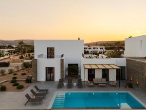 a villa with a swimming pool and a sunset at Villa Sabbia in Mesochórion