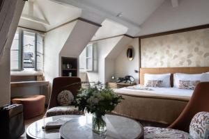 a hotel room with a bed and a table and chairs at Esprit Saint Germain in Paris