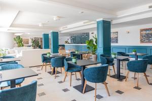 a restaurant with blue walls and tables and chairs at CDSHotels Le Castella - Ninfe Saracene in Le Castella