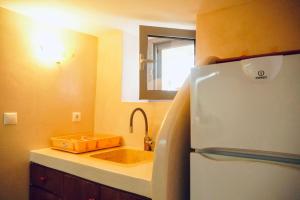 a kitchen with a sink and a refrigerator at Case De Drymona 1 in Kythira +7 photos