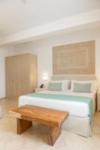 a bedroom with a large bed and a wooden table at CDSHotels Le Castella - Ninfe Saracene in Le Castella +47 photos