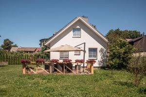 a house with a picnic table with an umbrella at Leonardo Vila Centre in Palanga