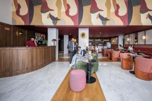 a group of people sitting in the lobby of a restaurant at Casa Falcão Boutique Hotel by Aspasios in Porto