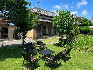 a group of chairs and a table in a yard at 館山ガーデンヴィラ 宮城ハウス - 平屋一棟貸し 屋根付きBBQ ペットok in Tateyama +44 photos