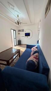 a living room with a blue couch and a table at Sidi kaouki Private House in Sidi Kaouki