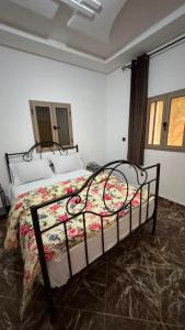a bedroom with a bed with a floral comforter at Sidi kaouki Private House in Sidi Kaouki