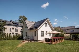a white house with an umbrella in the yard at Leonardo Vila Centre in Palanga