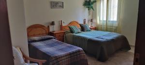 a bedroom with two beds and a window at El Rincón de Gredos in Navaluenga