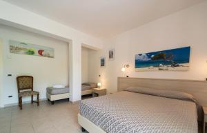 een slaapkamer met een bed en een stoel bij Hotel Punta Pina in Portoferraio