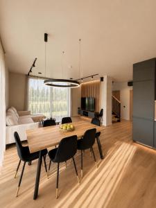 a dining room and living room with a table and chairs at SIA Green Guest House in Sigulda +5 photos