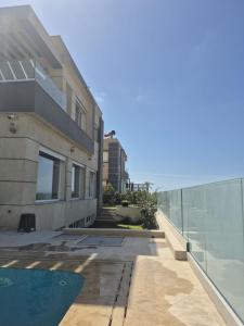 a building with a swimming pool next to a fence at Villa mnar 3 chambre en haut in Tangier +8 photos