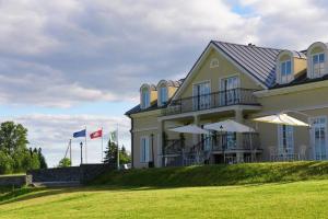 a large yellow house with umbrellas in front of it at Kambarys prie vynuogyno in Pikeliškės +13 photos