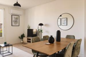 a living room with a wooden table and chairs at Le Traversant - Parking Gratuit in Bourg-lès-Valence