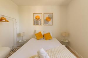 a white bedroom with two lamps and a bed at Le Traversant - Parking Gratuit in Bourg-lès-Valence