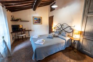 a bedroom with a bed with a blue bedspread at Podere Santa Maria in Monte Antico