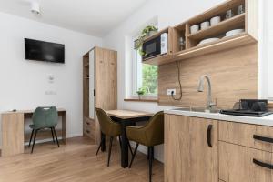 a kitchen with wooden cabinets and a table and chairs at ToTuLokum in Krakow