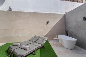 a bathroom with a bath tub and a bath tub at Odi Suite&Home in Maspalomas +40 photos