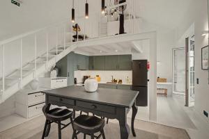 a kitchen with a table and two chairs and a staircase at The Village Barn in Caniço