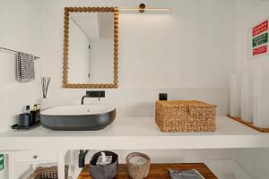 a bathroom with a sink and a mirror on a counter at The Village Barn in Caniço +14 photos