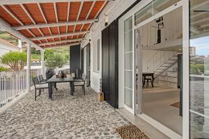 a patio with a table and stairs on a house at The Village Barn in Caniço