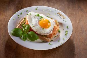 a white plate with an egg on top of toast at Hotel Goldene Steig in Kempten +30 photos