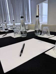 a table with bottles and glasses and a pen on it at Ox Hotel Manchester in Manchester