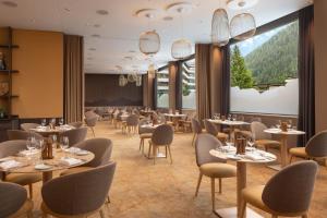 a restaurant with tables and chairs and a large window at Hilton Garden Inn Davos in Davos