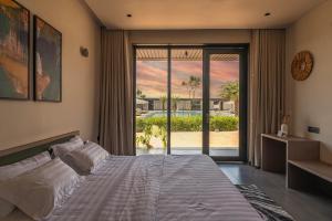 a bedroom with a large bed and a large window at Vanam at Sasan in Sasan Gir