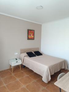 a bedroom with a bed and a nightstand and a table at Casa Alonso in Narón +7 photos