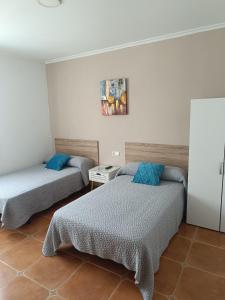 a room with two beds with blue pillows at Casa Alonso in Narón