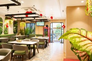 a restaurant with tables and chairs and a plant at Hotel Prabh Aasra Near Shree Ram Mandir in Ayodhya