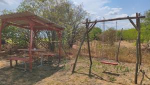 a picnic shelter with a picnic table and a bench at Levendula Vendégház in Ács