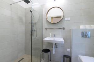 a bathroom with a shower and a sink and a mirror at Norbi cölöpház in Tiszafüred +52 photos