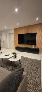 a living room with a tv and a couch and a table at The Loxwood Premier Suites in Accra