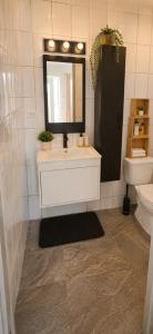 a bathroom with a sink and a mirror and a toilet at Island Vibes Apartment in Noord