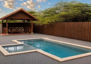 a swimming pool with a gazebo in a backyard at Island Vibes Apartment in Noord +2 photos