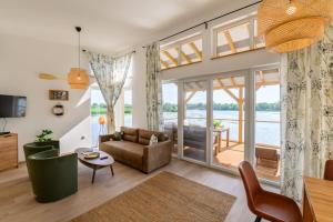 a living room with a view of the water at Norbi cölöpház in Tiszafüred
