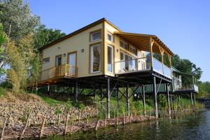 a house on stilts on the water at Norbi cölöpház in Tiszafüred