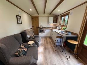 a living room with a couch and a kitchen at The Coach House or The Shepherd Hut in Blackpool