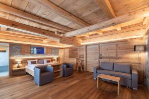 a bedroom with a bed and two chairs and a table at Hotel Crusch Alba Zernez in Zernez