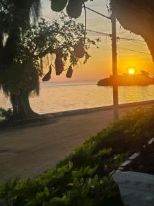 a sunset on a beach with the ocean in the background at A Tóca in Rio de Janeiro +6 photos