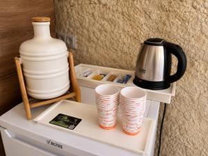 a shelf with cups and a pitcher and a coffee pot at Cappadocia Cave House in Ürgüp