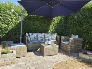 a patio with wicker furniture and an umbrella at Kastanie in Selb