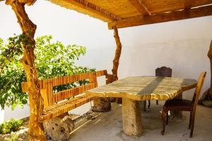 a wooden table and a bench on a porch at Case De Drymona 1 in Kythira
