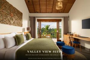 a bedroom with a bed and a desk and a balcony at ULU Valley Retreat in Tegalalang