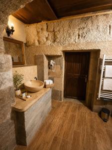 a bathroom with a sink in a stone wall at Cappadocia Cave House in Ürgüp +133 photos